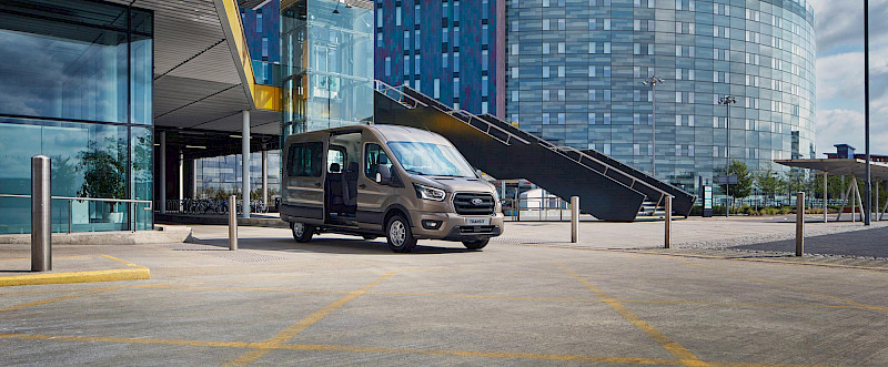 Ford Transit Minibusz áll egy épület előtt