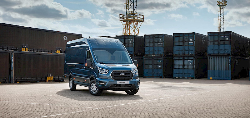 Ford Transit Van áll a konténerek előtt