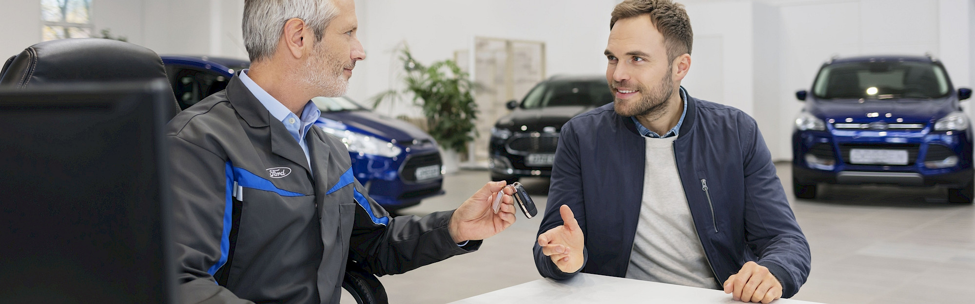 Ford szerelő és ügyfél beszélgetnek