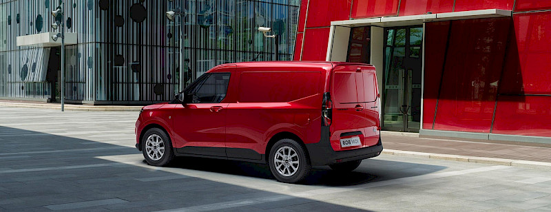 Ford Transit Courier modell parkol a piros épület előtt